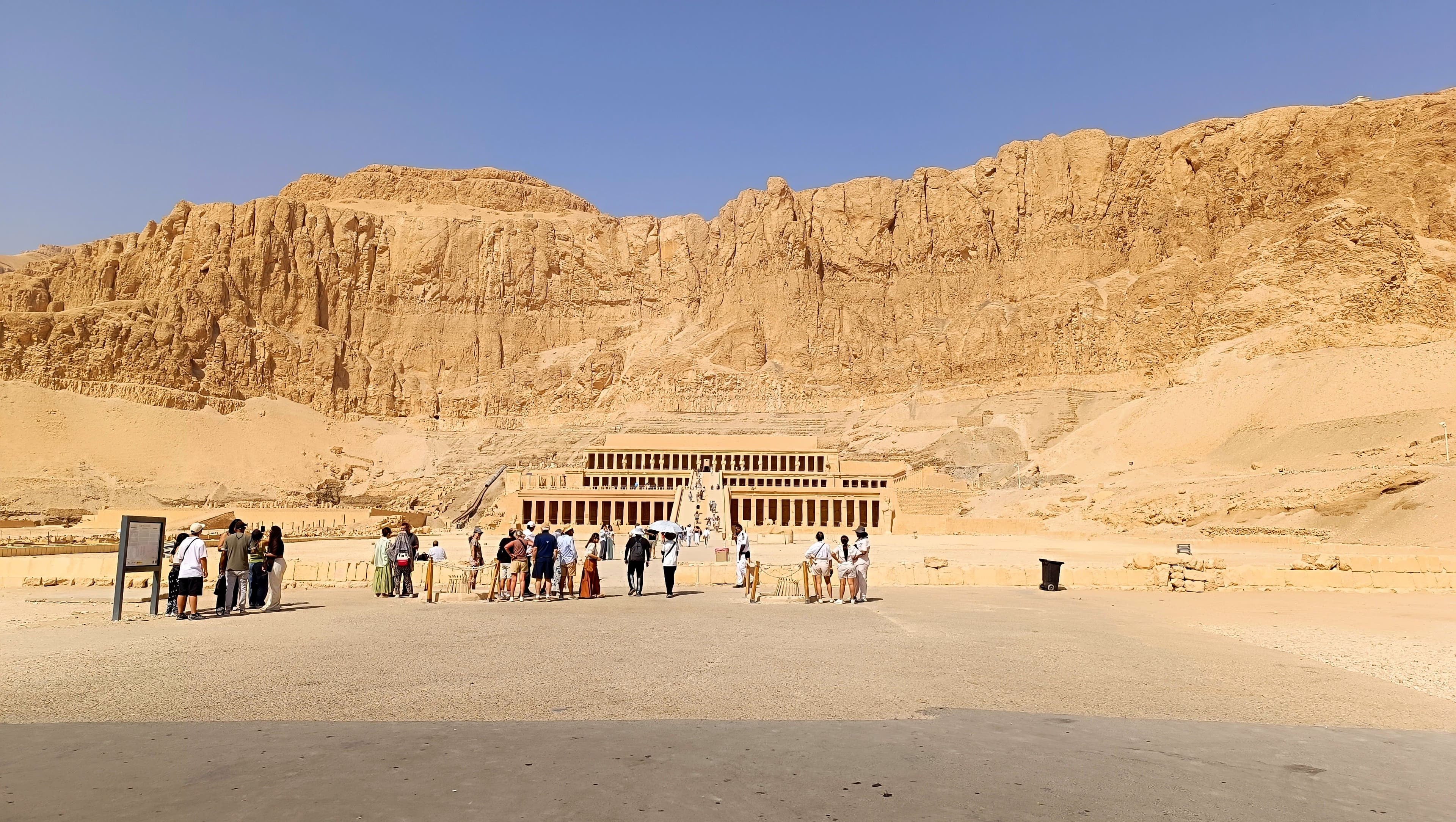 The full sweep of the temple beneath its cliffs.