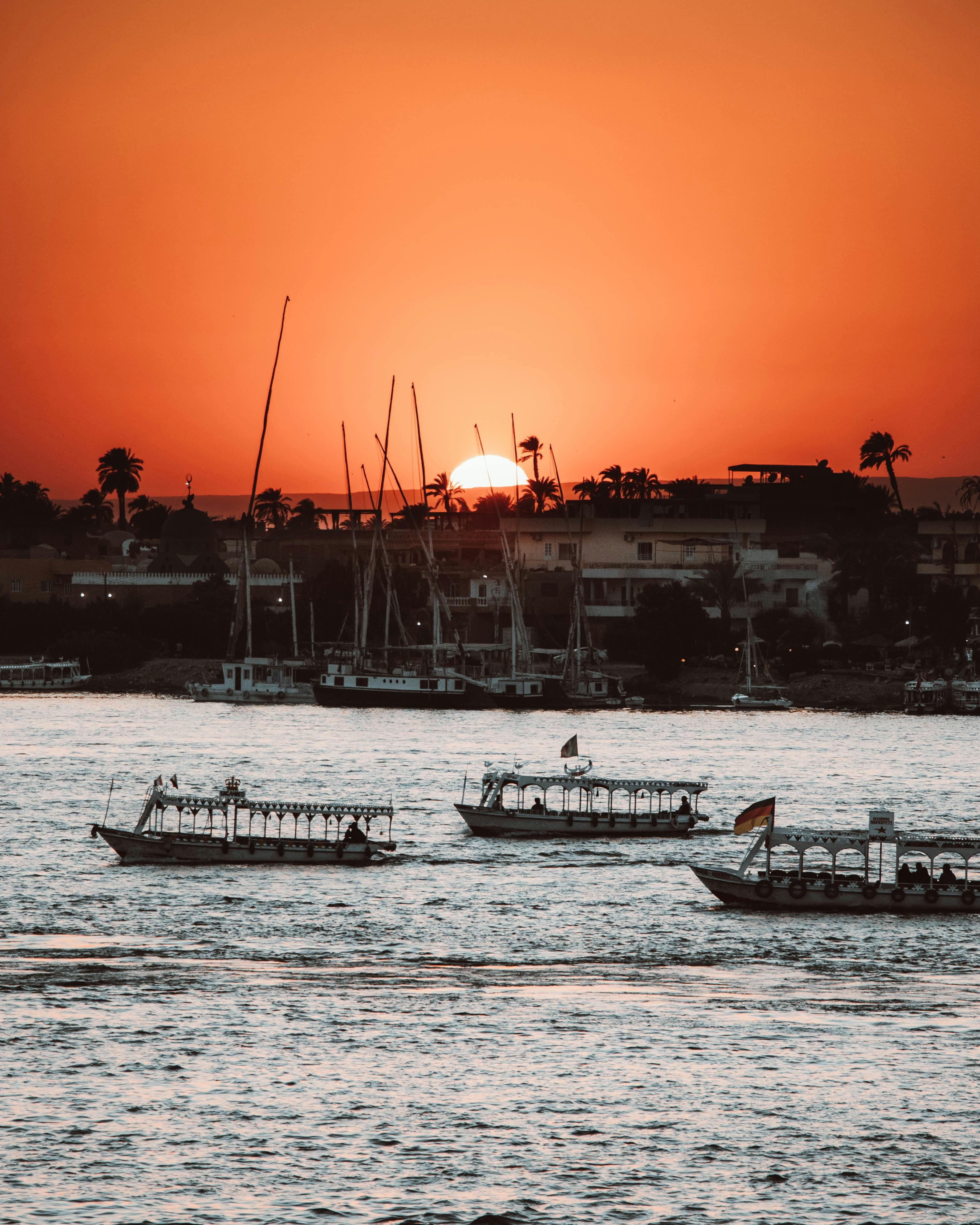 The boats in silhouette as the sun goes down.