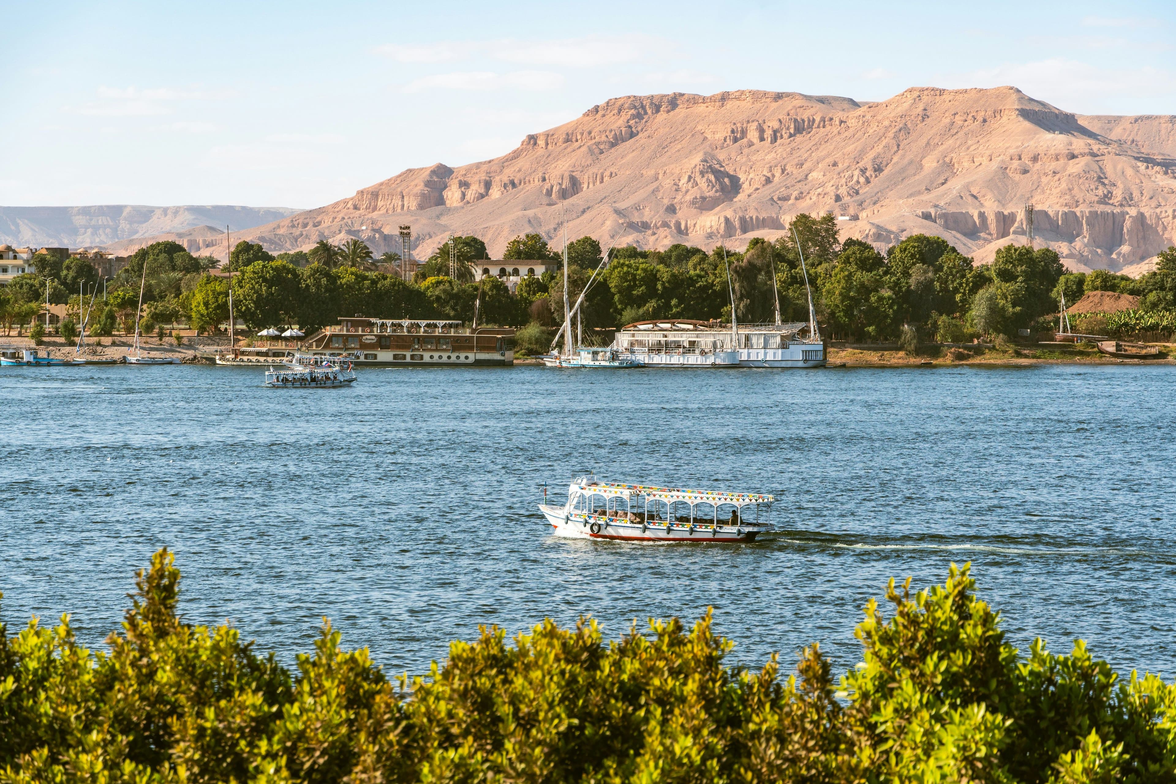 Traditional sailing boats moored on the Nile beneath the Theban mountains