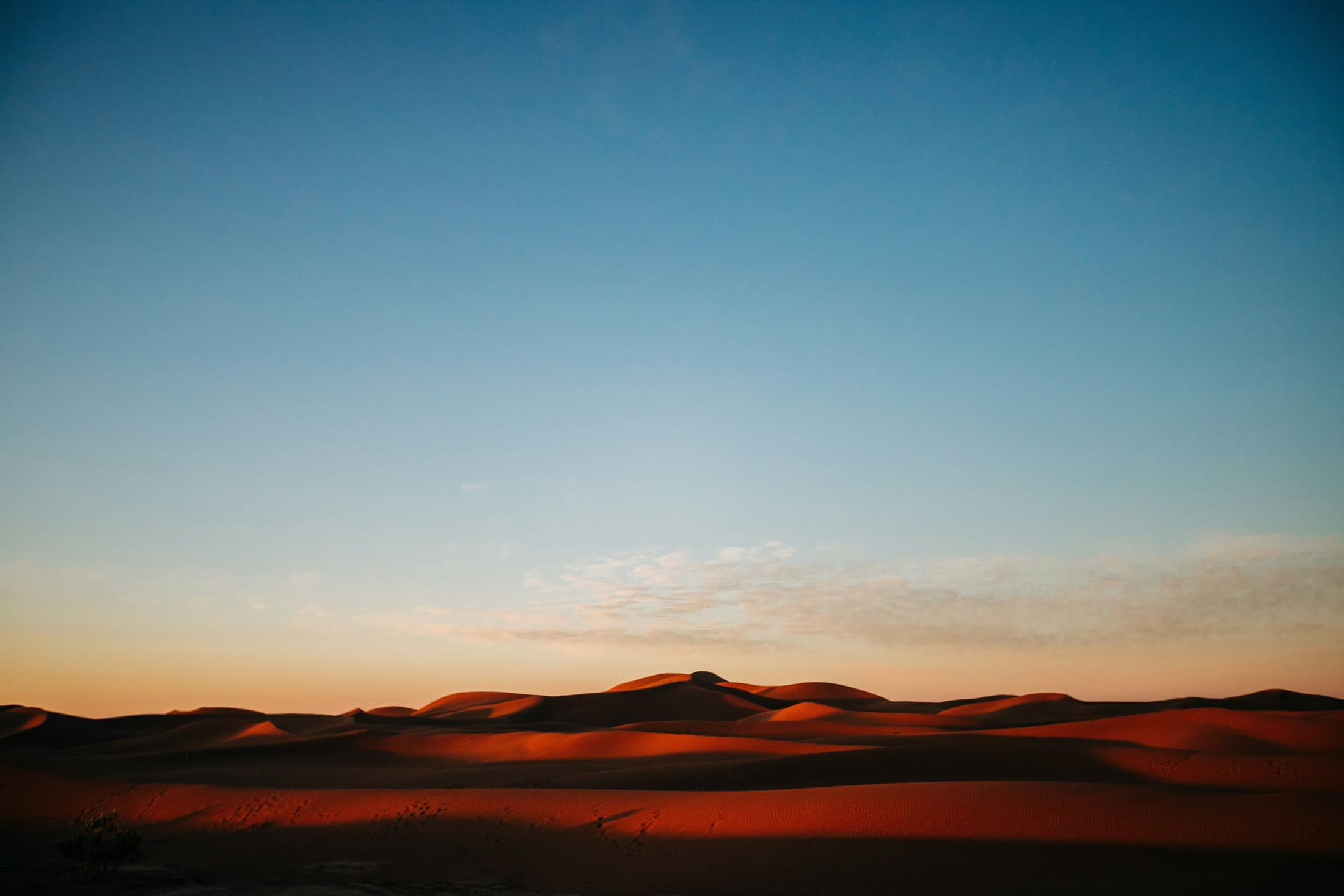 Red sand, at the hour the desert cools.